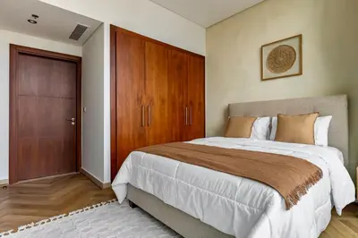 a bedroom with a large bed and a wooden cabinet at Private room in BURJ KHALIFA facing 3BR luxury apartment in Downtown Near Dubai Mall Metro in Dubai