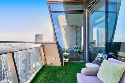 a balcony with a couch and chairs on a building at Private room in BURJ KHALIFA facing 3BR luxury apartment in Downtown Near Dubai Mall Metro in Dubai