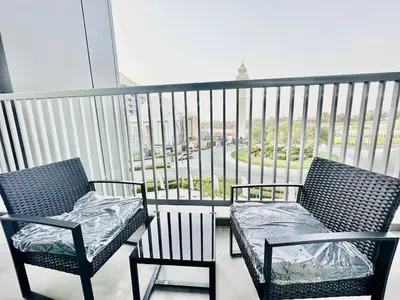 two chairs and a couch on a balcony at Modern 02 Bedroom in Sobha Crest B in Dubai