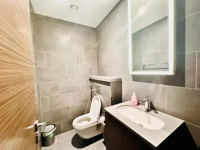 a bathroom with a white toilet and a sink at Modern 02 Bedroom in Sobha Crest B in Dubai
