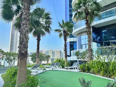 a resort with palm trees in front of a building at FIRST CLASS 2BR Mesmerizing Burj Khalifa View in Dubai