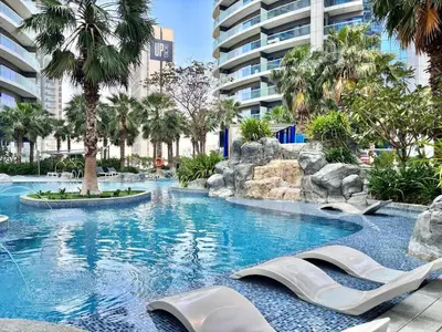 a swimming pool in a resort with palm trees at FIRST CLASS 2BR Mesmerizing Burj Khalifa View in Dubai