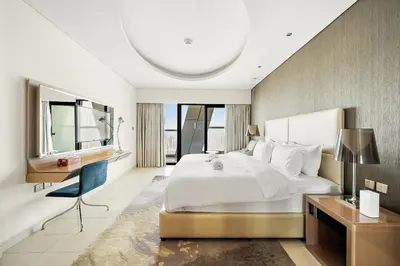 a bedroom with a large white bed and a desk at FIRST CLASS 2BR Mesmerizing Burj Khalifa View in Dubai