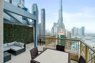 a balcony with a table and chairs and a view of the city at 2BR Downtown Gem with Burj Khalifa and Fountain Views in Dubai