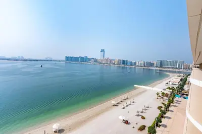 a view of a beach with beach chairs and buildings at Fantastic 2BR apartment Palm, Sea and Sunset Views in Dubai