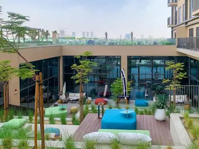 a building with a courtyard with chairs and tables at 1BR Little Haven in Collective T1, Dubai Hills in Dubai
