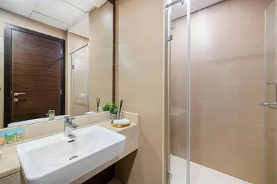 a bathroom with a sink and a glass shower at Sparkle Tower by Swarovski, Full Marina View, 2min JBR & Metro, Sleeps 4 in Dubai