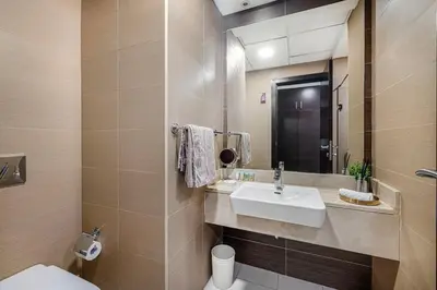 a bathroom with a sink and a toilet and a mirror at Sparkle Tower by Swarovski, Full Marina View, 2min JBR & Metro, Sleeps 4 in Dubai