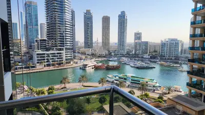 a river with boats in a city with tall buildings at Sparkle Tower by Swarovski, Full Marina View, 2min JBR & Metro, Sleeps 4 in Dubai
