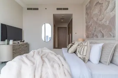 a white bedroom with a bed and a tv at The Smart Concierge - Stella Maris in Dubai