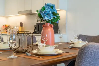a wooden table with a vase with blue flowers on it at The Smart Concierge - Jadeel 1 MJL in Dubai