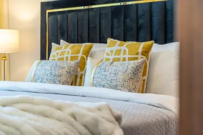 a bed with yellow and white pillows on it at The Smart Concierge - Jadeel 1 MJL in Dubai
