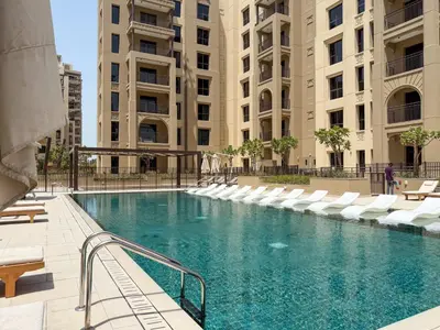 a swimming pool with white chairs and buildings at The Smart Concierge - Jadeel 1 MJL in Dubai