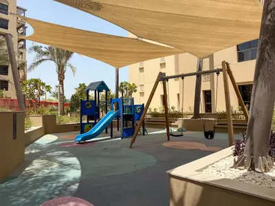 a playground with a slide and a swing set at The Smart Concierge - Jadeel 1 MJL in Dubai