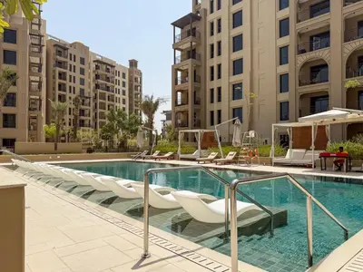 a swimming pool with lounge chairs in a building at The Smart Concierge - Jadeel 1 MJL in Dubai