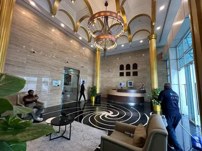 a lobby with a man standing in a building at Elegant 3BR Lux Stay in the Heart of Dubai Marina in Dubai