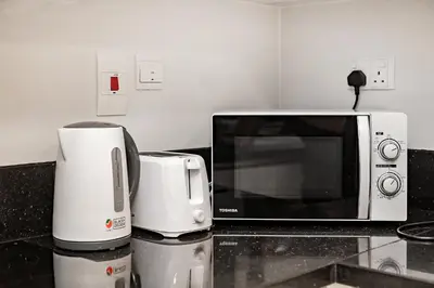 a microwave and a coffee maker on a kitchen counter at Stylish 1BR Apartment at Meera Tower in Dubai