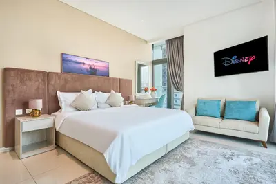 a bedroom with a large white bed and a couch at Beachfront Bliss, Seven Palm Studio Apartment in Dubai