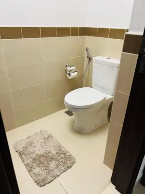 a bathroom with a toilet and a rug at Versatile 1BR with Burj Khalifa View in Dubai