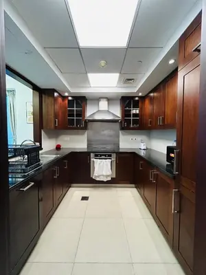 a large kitchen with wooden cabinets and a ceiling at Versatile 1BR with Burj Khalifa View in Dubai