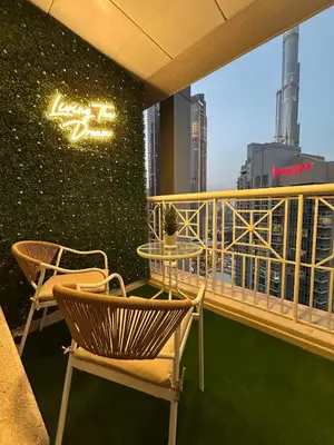 a balcony with chairs and a table on a building at Versatile 1BR with Burj Khalifa View in Dubai