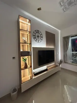 a living room with a television and a clock on the wall at Versatile 1BR with Burj Khalifa View in Dubai