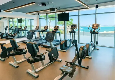 a gym with a lot of treadmills and machines at Serene Ocean Views, 2BR Emaar Beachfront in Dubai