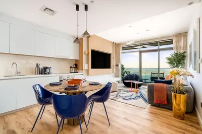 a kitchen and living room with a table and chairs at Serene Ocean Views, 2BR Emaar Beachfront in Dubai