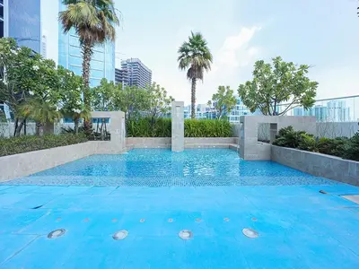 a swimming pool with blue water and palm trees at Luxury Studio | Near Dubai Mall | Lake View in Dubai