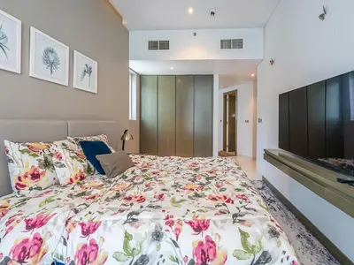 a bedroom with a large bed and a flat screen tv at Luxury Studio | Near Dubai Mall | Lake View in Dubai