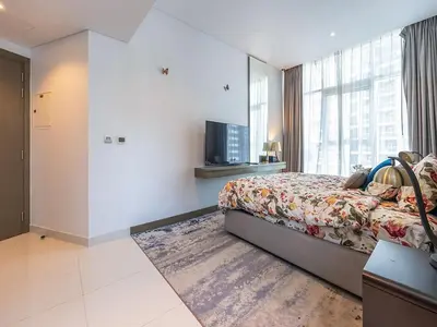 a hotel room with a bed and a television at Luxury Studio | Near Dubai Mall | Lake View in Dubai