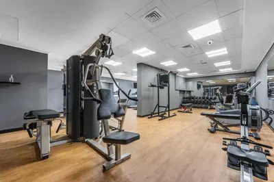 a gym with cardio equipment and tread machines at Modern Apt just Steps to Metro & Lake with Pool andParking in Dubai