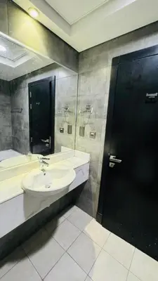 a bathroom with a sink and a black door at Oval Tower Retreat, Business Bay in Dubai