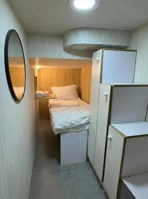 a small room with a bed and a mirror at Oval Tower Retreat, Business Bay in Dubai