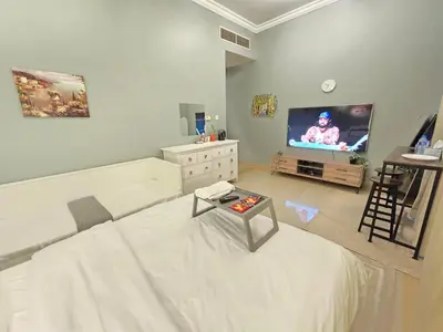 a living room with a white couch and a tv at Modern Studio Near Dubai World Trade Centre in Dubai