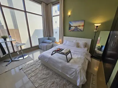 a bedroom with a large bed with a table on it at Charming Studio Near World Trade Center & Subway in Dubai