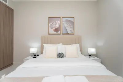 a bedroom with a large white bed with two lamps at Gala Guests - Elite Sea View Suites Dubai Marina in Dubai
