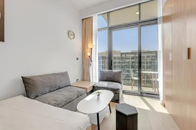 a living room with a couch and a table at Waves - Stylish and Comfy Couples Retreat Apt with Balcony in Dubai
