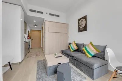 a living room with a couch and a table at Waves - Stylish and Comfy Couples Retreat Apt with Balcony in Dubai