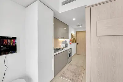 a kitchen with white cabinets and a stove top oven at Waves - Stylish and Comfy Couples Retreat Apt with Balcony in Dubai
