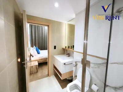 a bathroom with a sink and a toilet and a bed at 1BHK Pool Sauna 15 Min to Marina in Dubai