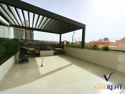a patio with a black pergola on a building at 1BHK Pool Sauna 15 Min to Marina in Dubai