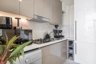 a kitchen with white cabinets and a stove top oven at Urban Chic Apartments in Dubai