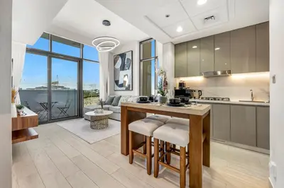 a kitchen with a island with bar stools at Urban Chic Apartments in Dubai