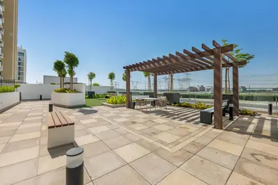 a patio with a wooden pergola and a table at Urban Chic Apartments in Dubai
