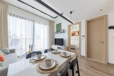 a dining room and living room with a table and chairs at Modern 1-BR Apartment with Cozy Vibes Pool Gym in Dubai