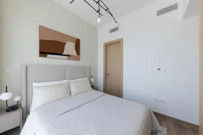 a white bedroom with a white bed in it at Modern 1-BR Apartment with Cozy Vibes Pool Gym in Dubai