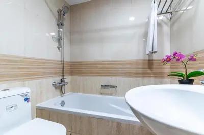 a bathroom with a tub and a toilet and a sink at The Smart Concierge - Marinascape Avant in Dubai