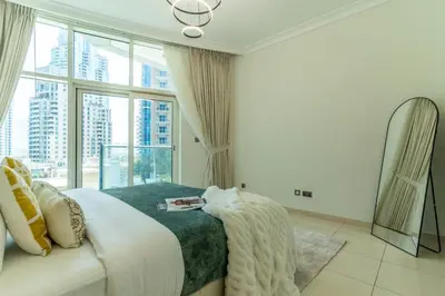 a bedroom with a bed and a large window at The Smart Concierge - Marinascape Avant in Dubai