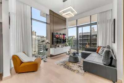 a living room with a couch and a tv at Stylish Apartment in Meydan in Dubai